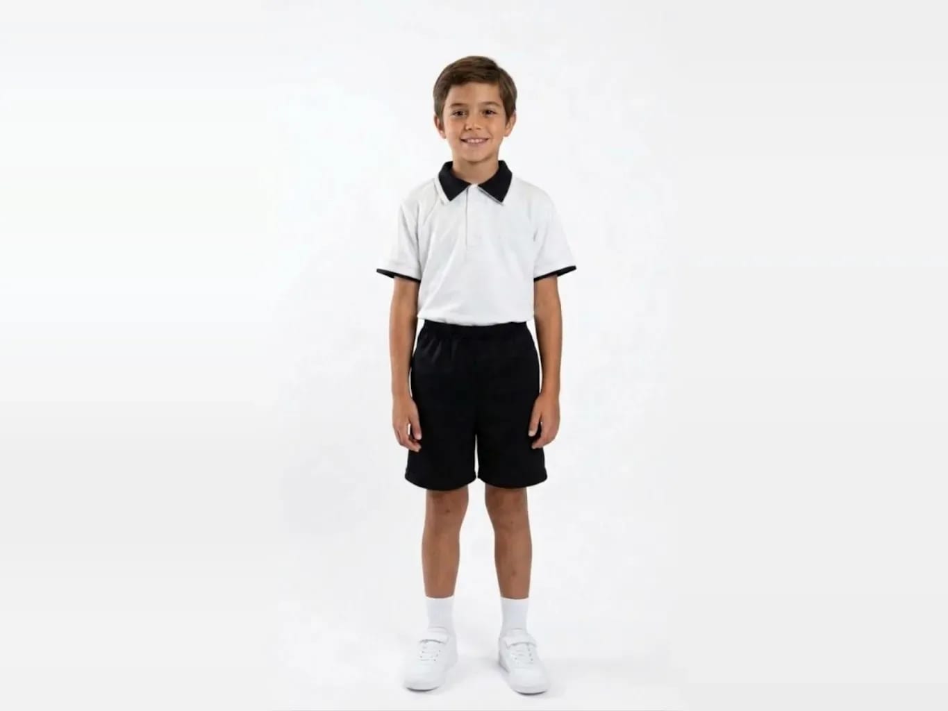 Estudiante con playera polo y short del uniforme oficial